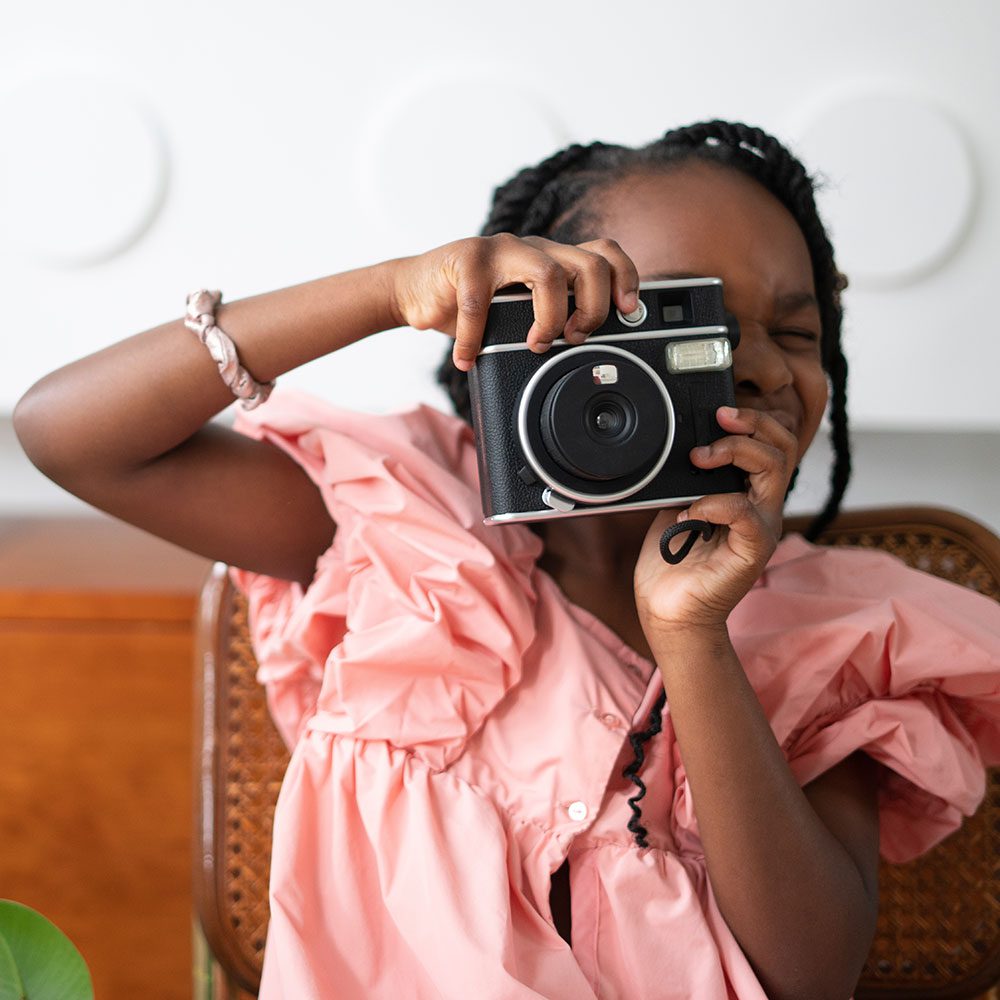 A girl with a camera, capturing moments as a budding photographer.