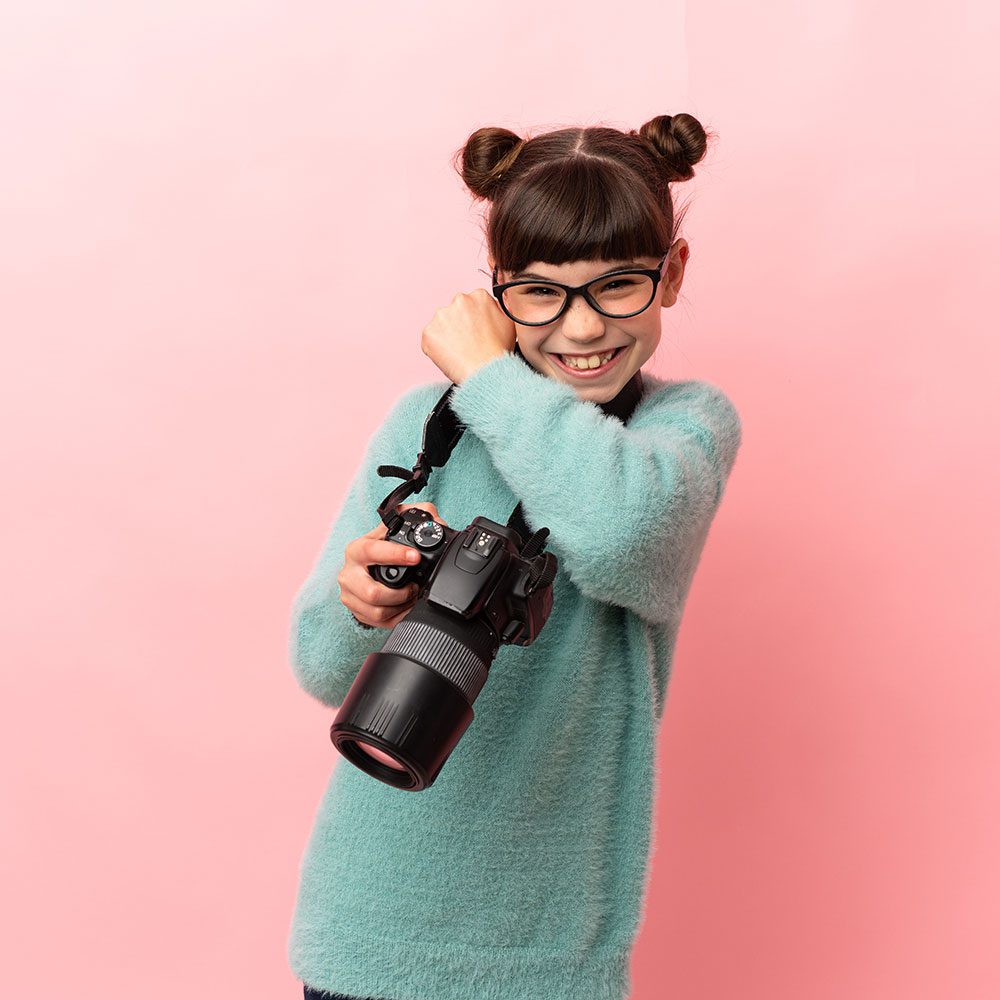 A girl with glasses capturing memories with her camera.